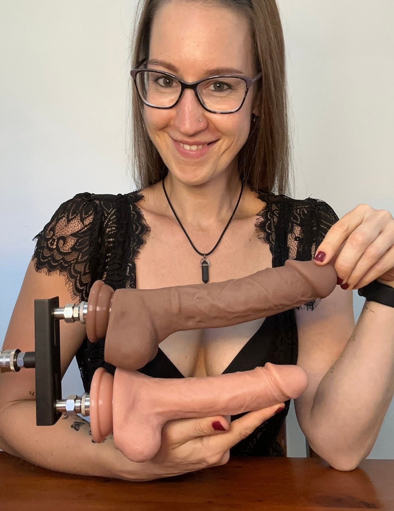 Pleasure Toy Queen Patricia holding the double dildo attachment for the sex machine