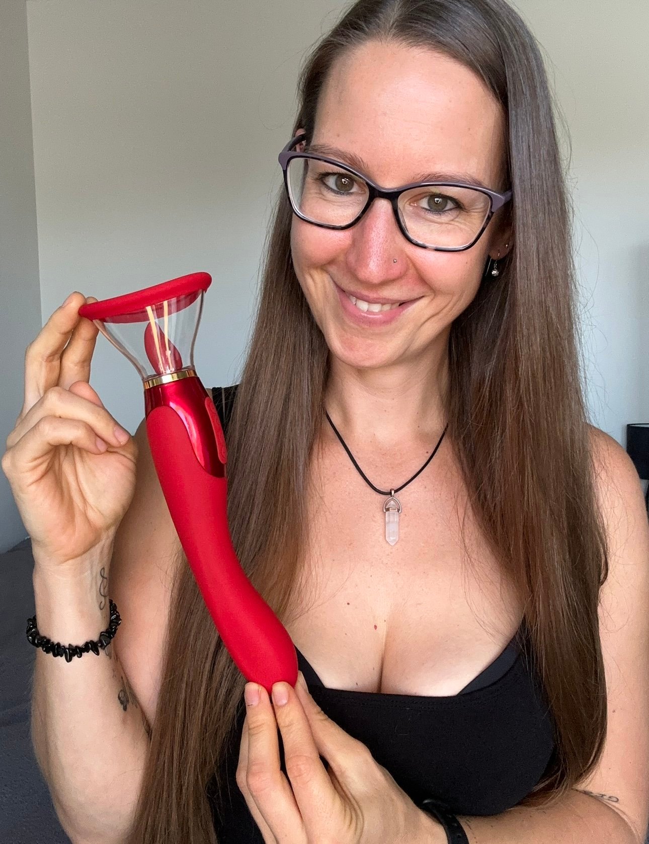 Pleasure Toy Queen Patricia holding a red tongue pump pleasure toy