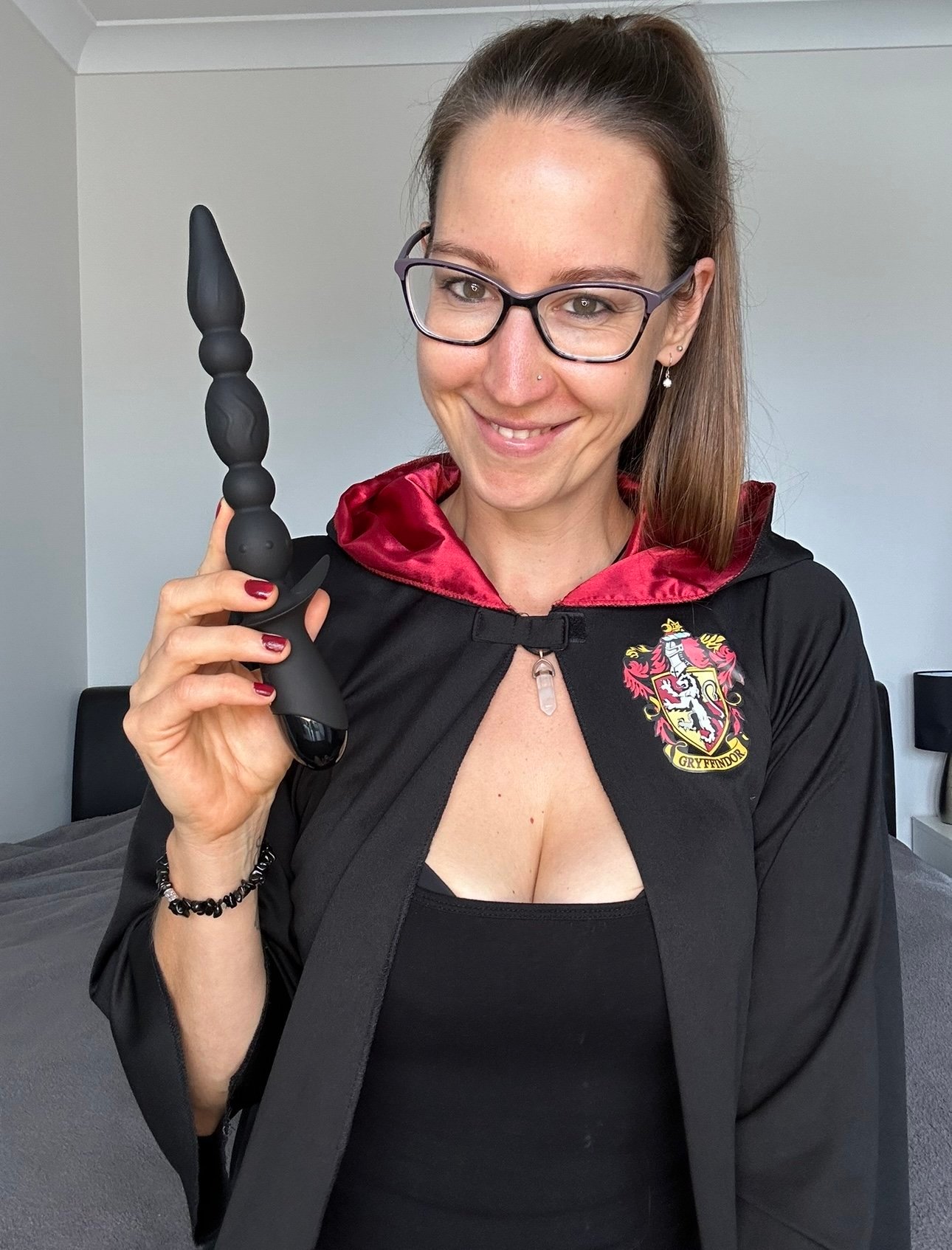 Pleasure Toy Queen Patricia holding the long black anal beads vibrator