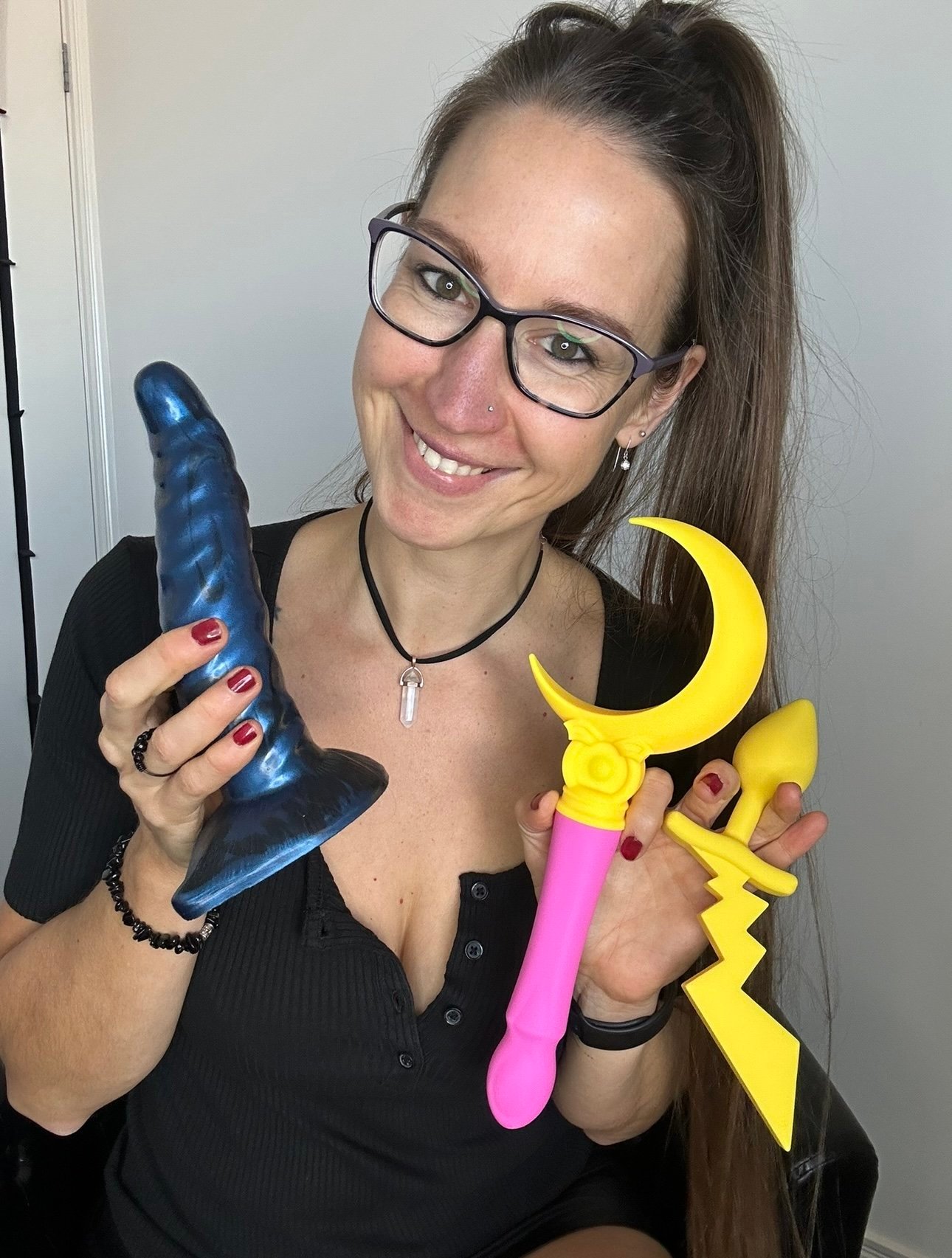 Pleasure Toy Queen Patricia holding various pleasure toys